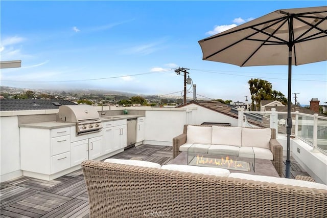 view of patio featuring area for grilling, exterior kitchen, sink, and an outdoor living space with a fire pit