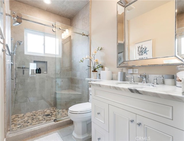 bathroom featuring tile patterned flooring, vanity, an enclosed shower, and toilet