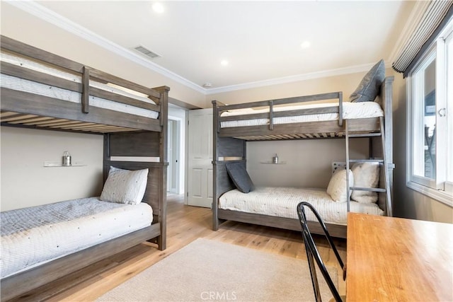 bedroom with crown molding and light wood-type flooring