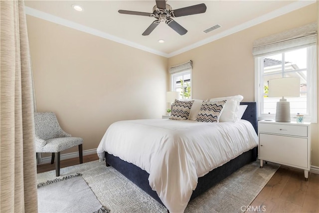 bedroom featuring ceiling fan, ornamental molding, and light wood-type flooring