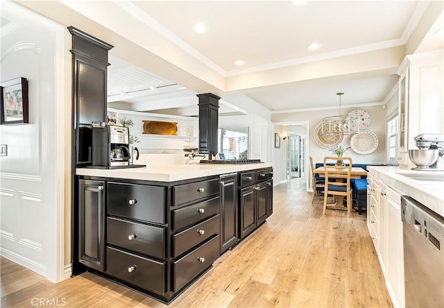 kitchen featuring white cabinets, ornamental molding, decorative light fixtures, light hardwood / wood-style floors, and stainless steel appliances