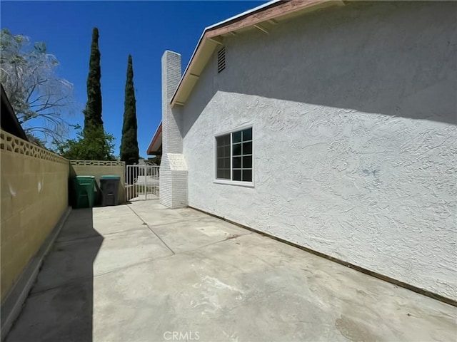 view of property exterior with a patio area