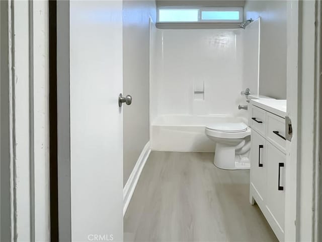 full bathroom with toilet, bathing tub / shower combination, hardwood / wood-style floors, and vanity