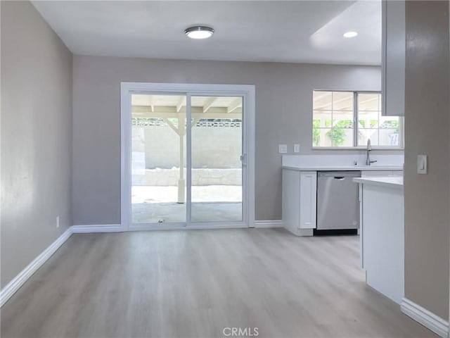 interior space with light hardwood / wood-style floors, plenty of natural light, dishwasher, and sink