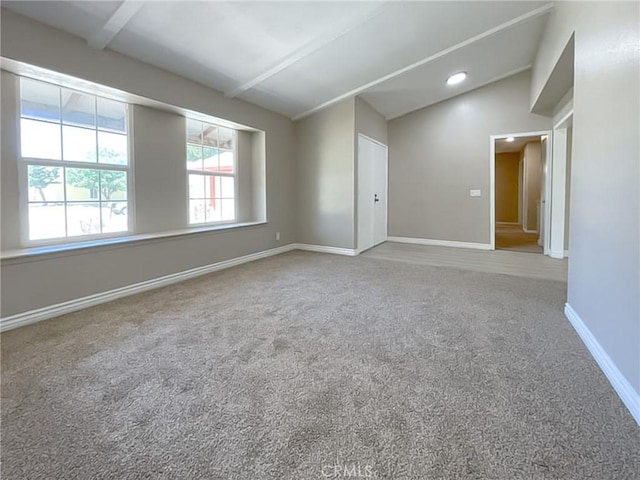 unfurnished room featuring carpet floors and lofted ceiling with beams