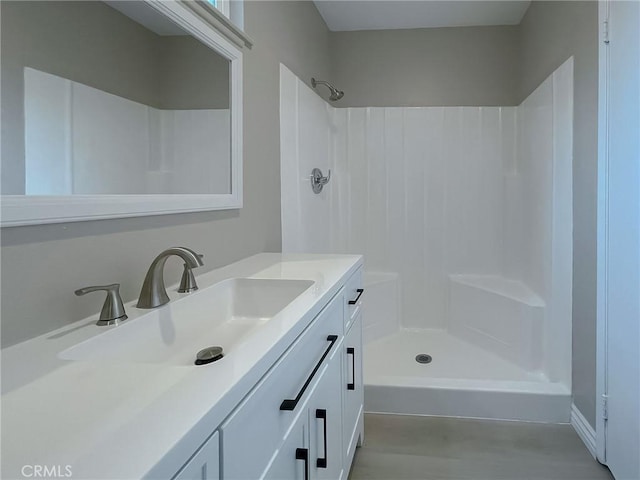 bathroom with walk in shower and vanity