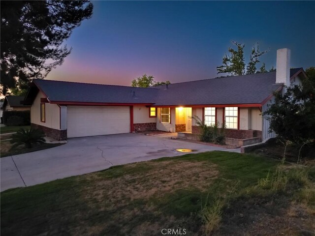 single story home with a lawn and a garage