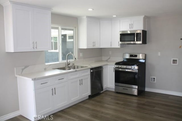 15814 Septo St, North Hills, CA 91343 - kitchen featuring appliances with stainless steel finishes, a sink, white cabinetry, dark wood finished floors, and baseboards