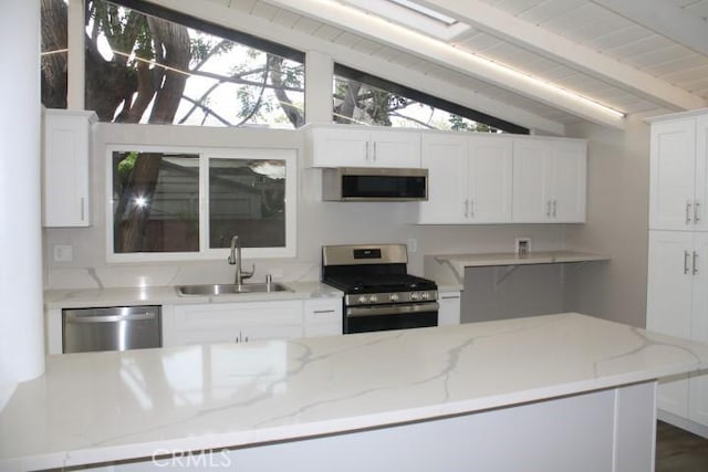 kitchen with appliances with stainless steel finishes, white cabinetry, sink, vaulted ceiling with beams, and light stone countertops