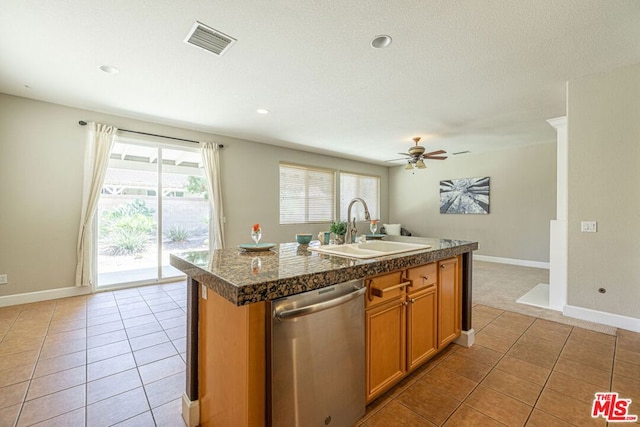 kitchen featuring ceiling fan, an island with sink, light tile patterned floors, sink, and dishwasher