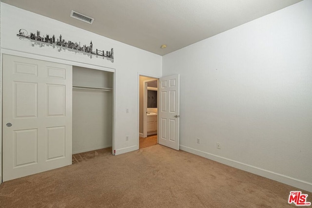 unfurnished bedroom featuring a closet and light colored carpet