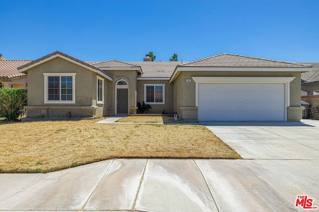 single story home with a garage and a front lawn