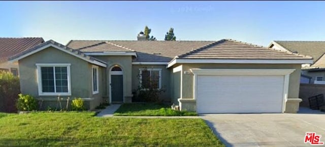 ranch-style house featuring a front lawn and a garage