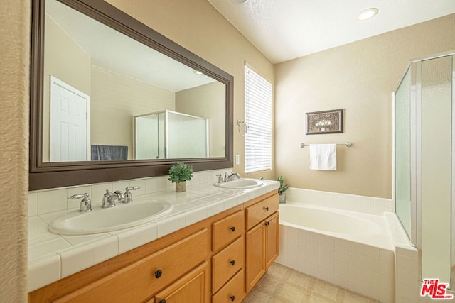 bathroom featuring vanity and independent shower and bath