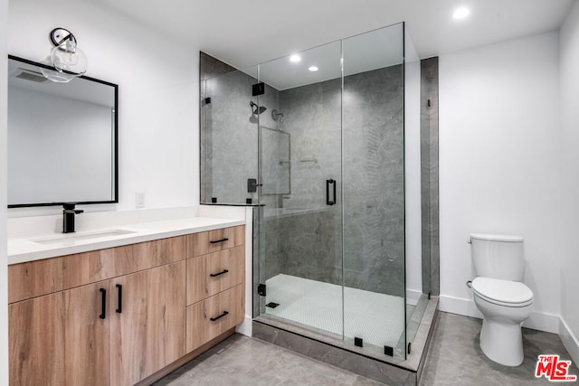 bathroom featuring vanity, walk in shower, and toilet