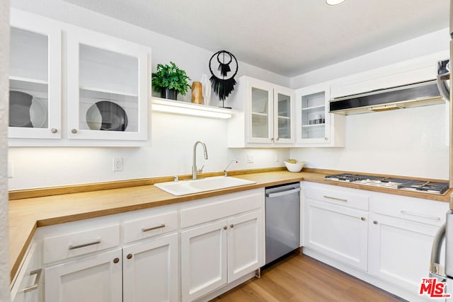 kitchen with sink, dishwasher, white cabinetry, gas stovetop, and light wood-type flooring