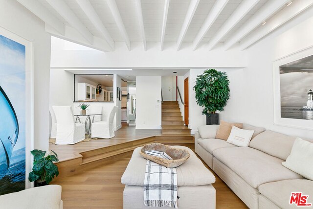 living room featuring wood-type flooring and beam ceiling