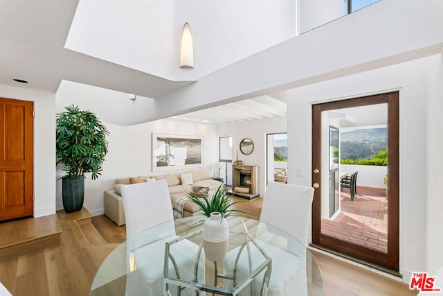 dining room with beam ceiling and light hardwood / wood-style floors