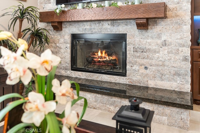 details with a stone fireplace and tile patterned flooring