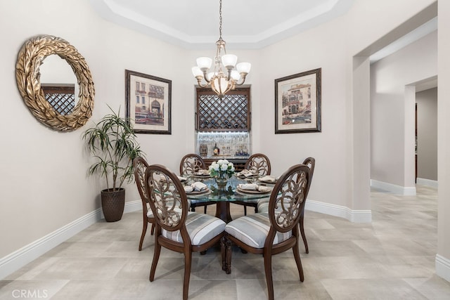 dining room featuring a tray ceiling and a chandelier