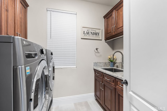 clothes washing area featuring sink, independent washer and dryer, light wood-type flooring, and cabinets