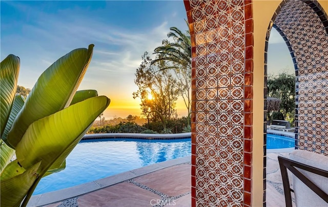 pool at dusk featuring an outdoor pool