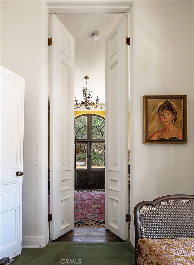 hall with an inviting chandelier and french doors