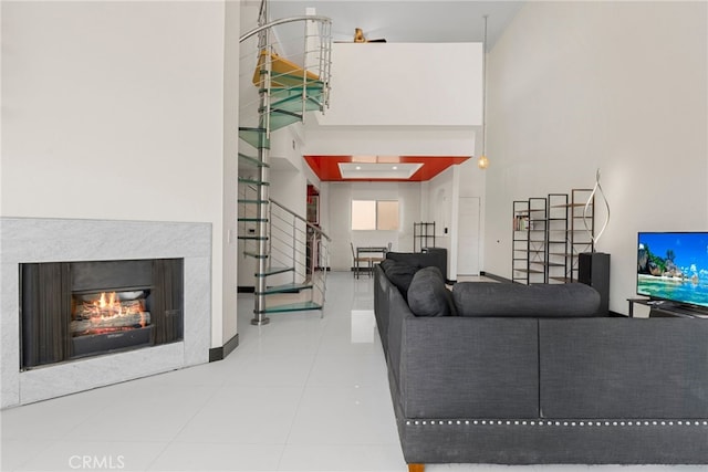 living area with a warm lit fireplace and a towering ceiling