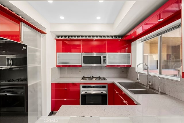 4301 Fulton Ave Unit 301, Sherman Oaks, CA 91423 - kitchen with stainless steel appliances, a sink, red cabinets, tasteful backsplash, and recessed lighting