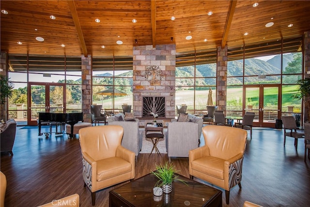 living room with a mountain view, wooden ceiling, expansive windows, and french doors