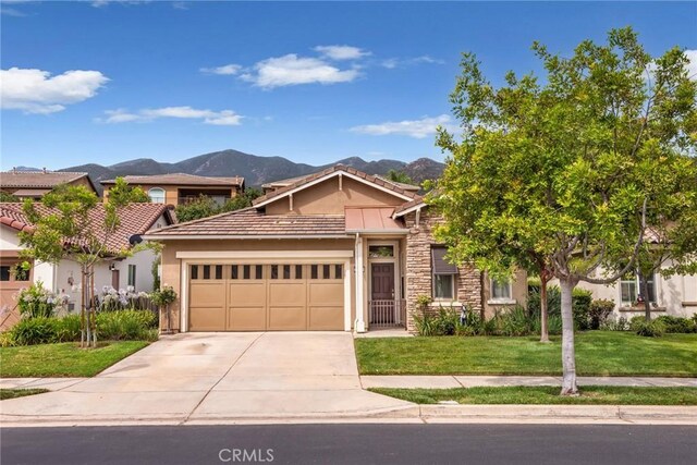 view of front of house with a mountain view, a front lawn, and a garage