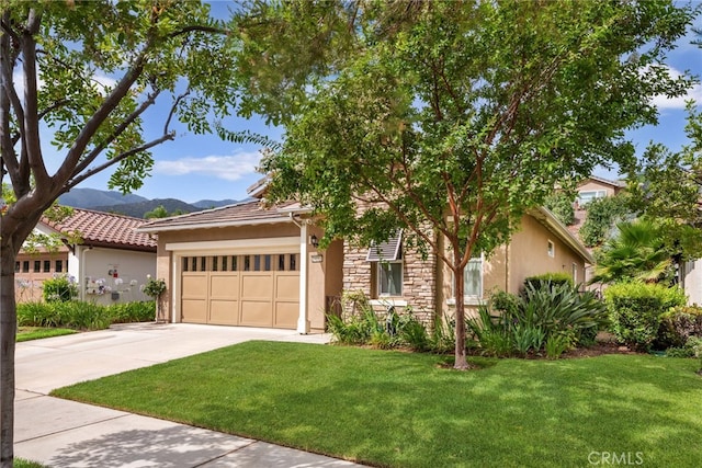 view of front of house featuring a mountain view, a garage, and a front lawn