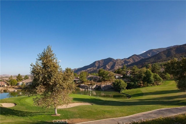 view of community featuring a water and mountain view and a lawn