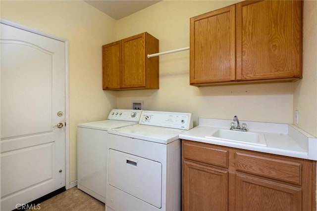 washroom featuring cabinets, washing machine and dryer, and sink