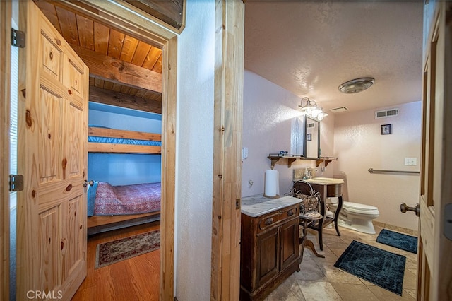 bathroom with wood ceiling, beamed ceiling, wood-type flooring, toilet, and sink