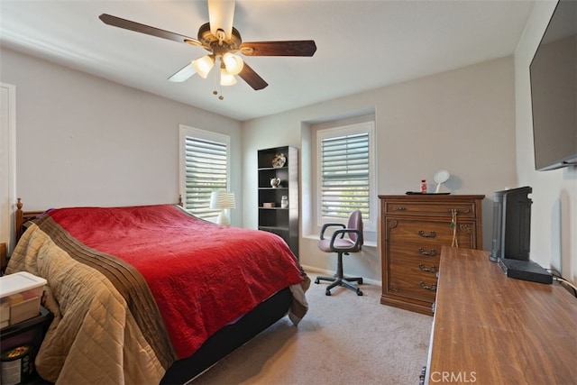 bedroom featuring multiple windows, ceiling fan, and light carpet