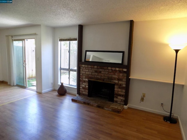 unfurnished living room with a fireplace, hardwood / wood-style floors, and a textured ceiling