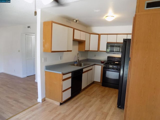 kitchen featuring black appliances, light hardwood / wood-style floors, white cabinetry, and sink