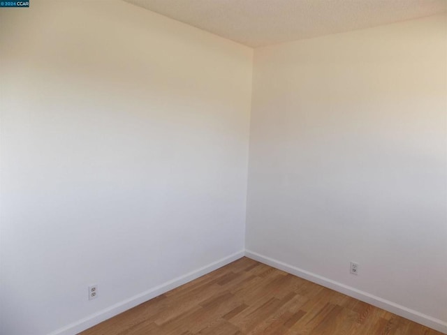 unfurnished room with hardwood / wood-style flooring