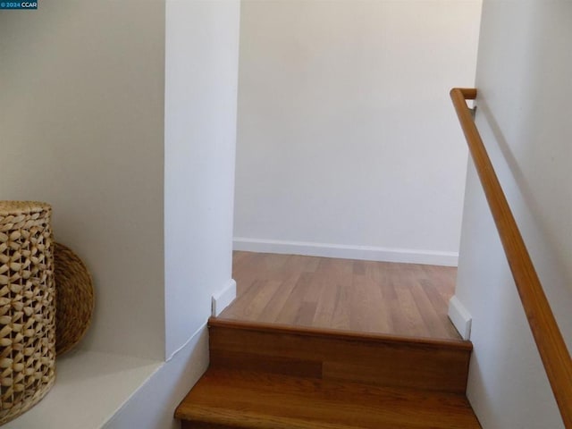 stairway with hardwood / wood-style floors