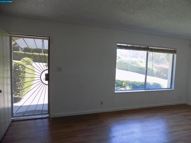 foyer with dark hardwood / wood-style flooring and a textured ceiling