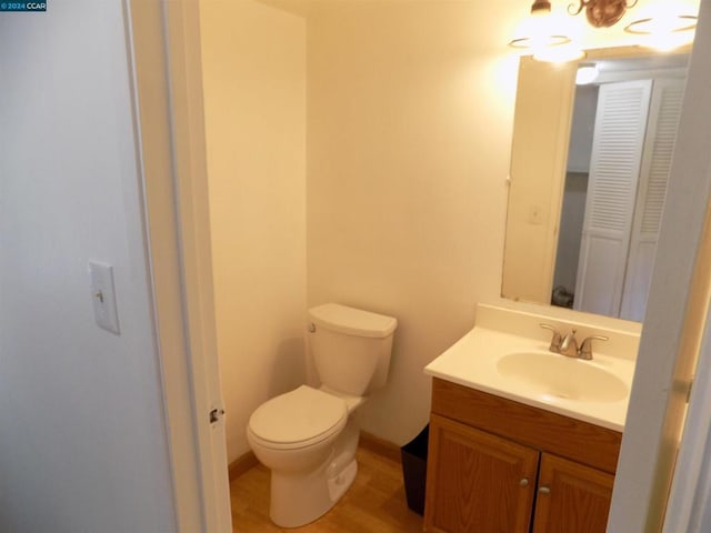 bathroom with hardwood / wood-style floors, vanity, and toilet