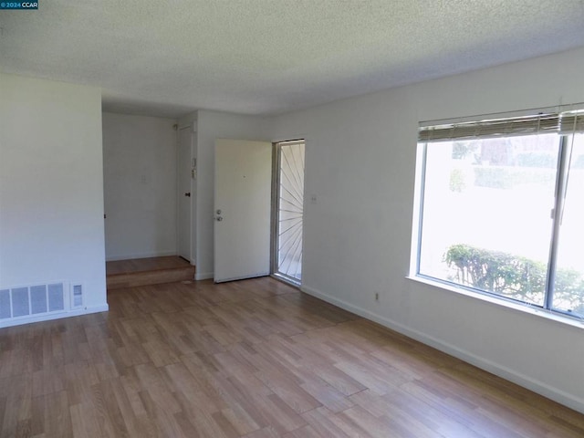 empty room featuring light hardwood / wood-style flooring and a textured ceiling