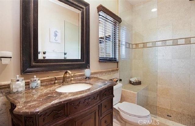 bathroom featuring vanity, tiled shower, and toilet