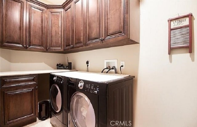 clothes washing area featuring cabinets and washer and dryer