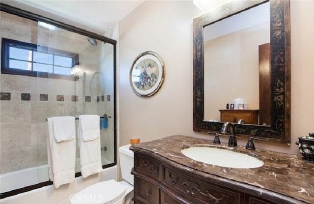 full bathroom with vanity, enclosed tub / shower combo, and toilet