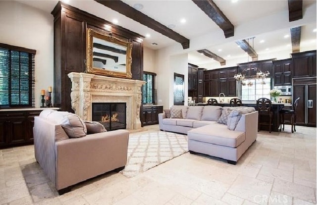 living room featuring a notable chandelier, a fireplace, and beamed ceiling