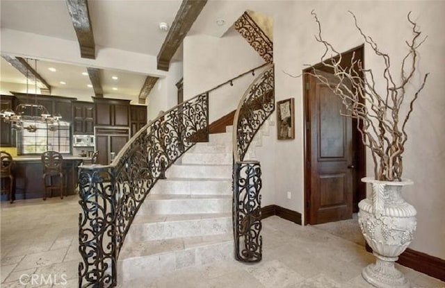 stairway featuring beam ceiling and a notable chandelier