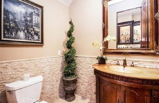 bathroom featuring vanity, toilet, and vaulted ceiling