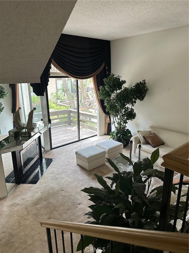 living room with plenty of natural light, carpet, and a textured ceiling